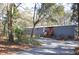 Gray mobile home with red door, steps, and American flag, nestled in woods at 6321 Bears Bluff Rd, Wadmalaw Island, SC 29487