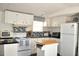 White kitchen with island and modern appliances at 6321 Bears Bluff Rd, Wadmalaw Island, SC 29487
