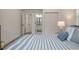 Serene bedroom featuring blue and white striped bedding and an ensuite bathroom at 7311 Indigo Palms Way, Johns Island, SC 29455