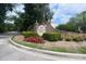 The Indigo Hall community entrance features a brick sign with pineapple accents surrounded by lush landscaping and mature trees at 7311 Indigo Palms Way, Johns Island, SC 29455