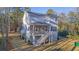 Back exterior view of elevated home with screened porch, stairs, wooded lot, and lush green lawn at 0 United Dr, Huger, SC 29450