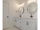 Bathroom with double sinks, round mirrors, black hardware, and bright white cabinetry at 0 United Dr, Huger, SC 29450
