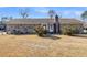Wide backyard view of the house showing brick exterior, chimney, shrubs, and fenced yard at 101 Winston Cir, Summerville, SC 29485