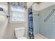Bathroom with a toilet, window, and blue tile shower featuring a blue shower curtain at 101 Winston Cir, Summerville, SC 29485