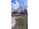 A view of a backyard with mature trees, sidewalk, and a storage building at 102 Barrington Blvd, Goose Creek, SC 29445
