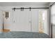 Main bedroom with white sliding barn doors and access to the bathroom at 1385 Fairfield Ave, Charleston, SC 29407