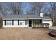 Tan vinyl-sided house with gray roof, black shutters, and small porch at 186 Bridgecreek Dr, Goose Creek, SC 29445
