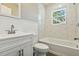 Bathroom features a shower and tub with white vanity and marble-like tile at 213 Rose Ave, Walterboro, SC 29488