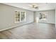 Bedroom with gray vinyl floors, neutral walls, ceiling fan, and bright windows at 213 Rose Ave, Walterboro, SC 29488
