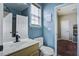 Bright bathroom with a wooden vanity, white toilet and a blue accent wall at 221 Trillium Ave, Summerville, SC 29483
