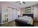 Bright bedroom with a ceiling fan and a decorative mirror and a doorway to a bathroom at 221 Trillium Ave, Summerville, SC 29483