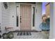 A welcoming pink front door with glass sidelights and a cozy porch setup with seating at 221 Trillium Ave, Summerville, SC 29483