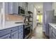 Contemporary kitchen with gray cabinets, stainless steel appliances, and an open layout flowing into the living area at 221 Trillium Ave, Summerville, SC 29483