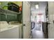 Functional laundry room with a washer, dryer, storage shelves, and a view into the adjacent kitchen area at 221 Trillium Ave, Summerville, SC 29483