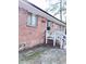 View of the home's exterior featuring brick, a white banister and mature trees in the yard at 227 Bailey St, Walterboro, SC 29488