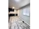 Kitchen with neutral-toned floors, a window, a white door, and classic black cabinetry at 227 Bailey St, Walterboro, SC 29488