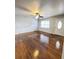 Bright living room with hardwood floors, a ceiling fan, a large window, and a white front door at 227 Bailey St, Walterboro, SC 29488