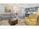 Open living room features gray sectional sofa, yellow armchair, and a view into the kitchen at 2725 Battery Pringle Dr, Johns Island, SC 29455