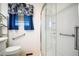 Bathroom with a walk-in shower, toilet, blue curtains, and safety grab bars at 2830 Wire Rd, Saint George, SC 29477