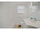 All-white bathroom with tub and shower combination features updated fixtures and lots of natural light at 2830 Wire Rd, Saint George, SC 29477