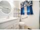 Bright bathroom featuring a vanity, toilet, chrome shelving, and elegant blue curtains at 2830 Wire Rd, Saint George, SC 29477