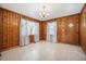 Inviting dining area featuring wood paneling, classic chandelier, and natural light from draped windows at 2830 Wire Rd, Saint George, SC 29477
