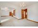 Bright living room featuring plush carpeting, white walls, and elegant chandeliers with wooden trim throughout at 2830 Wire Rd, Saint George, SC 29477