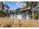 Exterior of a home with a large deck, set amidst lush greenery and trees for ultimate privacy at 2947 Deer Point Dr, Seabrook Island, SC 29455