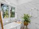Soaking tub next to a window with marble tile, and a view of the surrounding landscape at 2947 Deer Point Dr, Seabrook Island, SC 29455