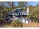 Beautiful exterior of home featuring elevated deck, large windows, and mature trees at 2947 Deer Point Dr, Seabrook Island, SC 29455