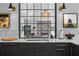 Close-up of the kitchen featuring marble countertops, a stainless steel sink, and large black pane windows at 2947 Deer Point Dr, Seabrook Island, SC 29455
