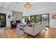Bright living room features a stone fireplace, hardwood floors, modern lighting, and access to outdoor living at 2947 Deer Point Dr, Seabrook Island, SC 29455