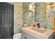 Charming powder room with colorful wallpaper, stone countertop, and a brass mirror at 2947 Deer Point Dr, Seabrook Island, SC 29455