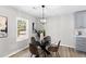 Cozy dining area with a glass table, modern light fixture, and view of the outdoor landscape at 3 Coral Dr, Goose Creek, SC 29445