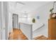 Hallway with hardwood floors, white walls, and minimalist decor, providing a clean and bright transition space at 313 Lapwing Ln, Mount Pleasant, SC 29464