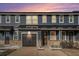 Modern two-story townhome with dark gray siding, stone accents, and a dark brown garage door at 5135 Park Creek Avenue, North Charleston, SC 29418