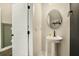 Stylish powder room with pedestal sink and oval mirror at 5135 Park Creek Avenue, North Charleston, SC 29418