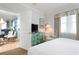 Bright bedroom features an accent chair, a mounted TV, and a glimpse into a dining and living area at 5804 Palmetto Dr # A-401/403, Isle of Palms, SC 29451