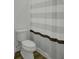 Bathroom with toilet, wood floor and a striped shower curtain providing a private bathing space at 637 N Laurel St # 75, Summerville, SC 29483