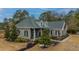 Two-story house with gray siding and brick accents, nestled on a wooded lot at 788 Awendaw Lakes Blvd, Awendaw, SC 29429