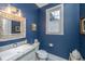 Stylish bathroom with blue walls, granite vanity, and decorative mirror at 788 Awendaw Lakes Blvd, Awendaw, SC 29429