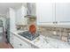 Modern kitchen with gas cooktop, granite countertops, and brick backsplash at 788 Awendaw Lakes Blvd, Awendaw, SC 29429