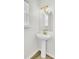 Updated bathroom with pedestal sink, gold fixtures, and arched mirror at 7897 Sabalridge Dr, North Charleston, SC 29418