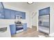 Modern kitchen featuring blue cabinets, stainless steel appliances, and wood flooring at 7897 Sabalridge Dr, North Charleston, SC 29418