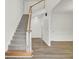 Open staircase with wood railing and neutral carpeting at 7897 Sabalridge Dr, North Charleston, SC 29418