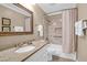 Well lit bathroom with granite countertops, framed mirror, and marble tiled shower and bath at 8000 Palmetto Dr # 505, Isle of Palms, SC 29451