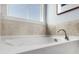 Bright bathroom featuring a large soaking tub with tiled walls and a frosted window above at 108 Maritime Way, Summerville, SC 29485