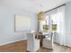 Bright dining area features a round table, four chairs, a stylish light fixture and large windows with neighborhood views at 108 Maritime Way, Summerville, SC 29485