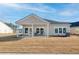 Home featuring a covered patio with chairs overlooking the spacious backyard with brown grass at 1170 Cane Creek Way, Summerville, SC 29485