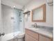 A stunning bathroom with a walk-in shower with light gray stone tiling, a wood frame mirror and sink with marble top at 1365 Dunlin Court, Share C, Kiawah Island, SC 29455